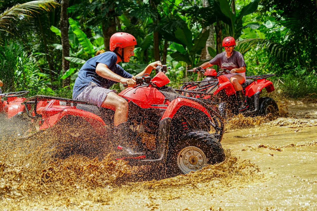 Group of ATV quad bikes powering through a muddy track in Ubud